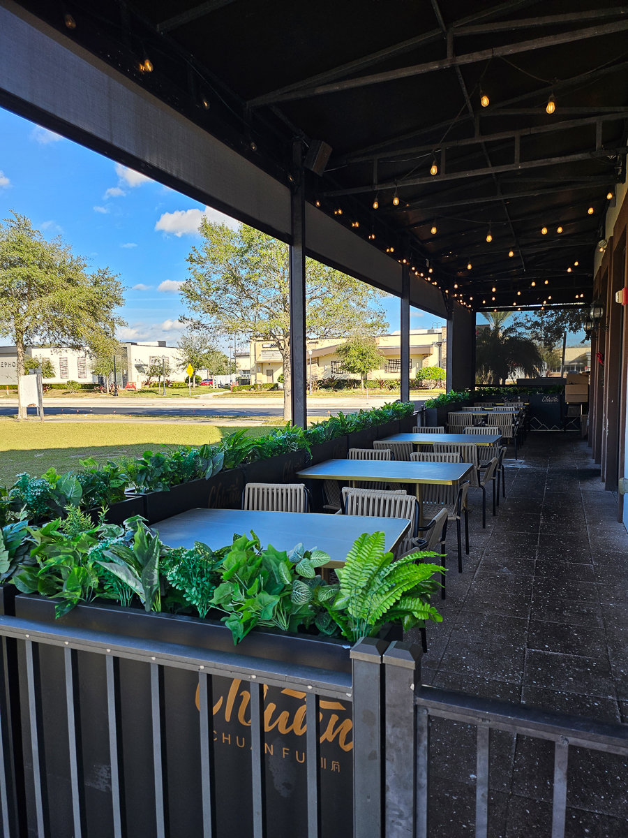 outdoor seating with hanging lights and greenery
